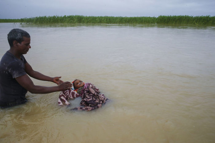 Мужчина хоронит племянника в реке, поскольку семья не смогла найти сухую землю, чтобы похоронить ребенка. Непал. Автор: Narendra Shrestha.
