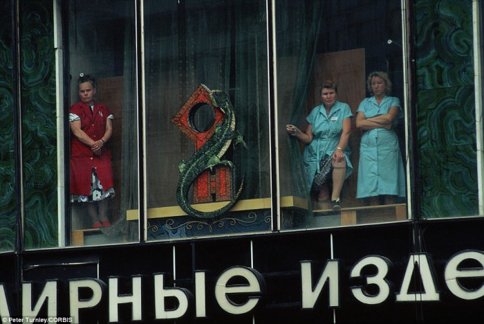 Женщины наблюдают за похоронами из окна ювелирного магазина после неудачной попытки государственного переворота в Москве.