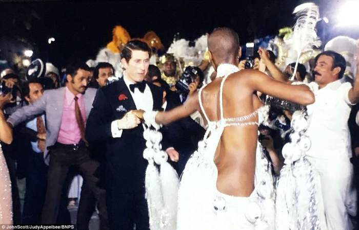  Чарльз в двубортном смокинге с большим галстуком-бабочкой танцует с полуобнажёнными бразильскими красавицами.