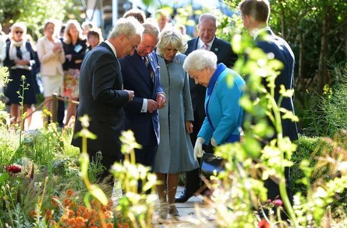 Камилла осматривает растения на выставке цветов в Челси в 2015 году с Чарльзом и покойной королевой Елизаветой 