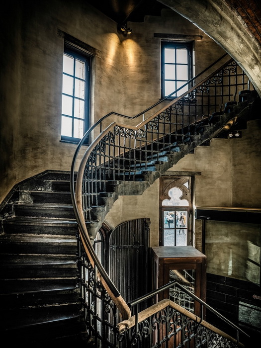Старинная лестница ведет на этаж, где располагаются комнаты.