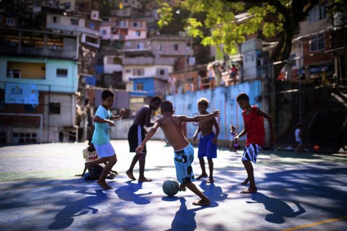 Мальчишки играют в футбол на улице.