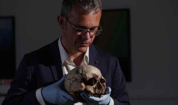 Ученый Ян Барнс держит в руках череп мужчины из Чеддара. Экспонат хранится в природно-историческом музее.