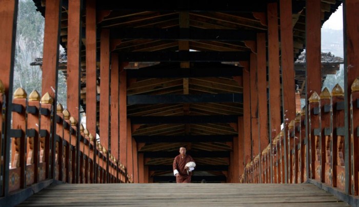Монах на традиционном деревянном мосту