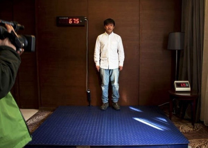 Китаец Ван Джан (Wang Jun) сбрасывает вес, стоя на весах