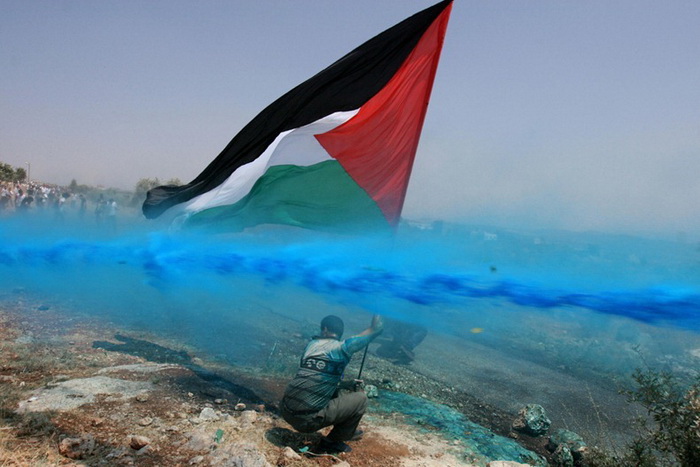 Мужчину с палестинским флагом поливают синей краской, 2006 г.