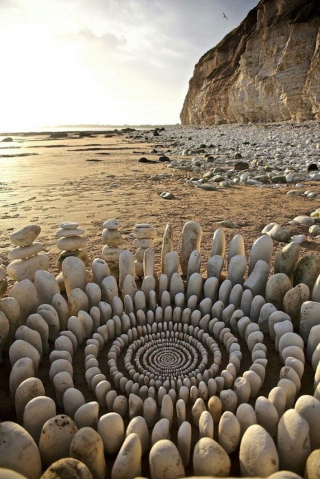 Ленд-арт из белоснежных камней на пляже.