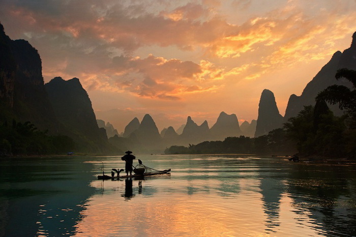 Бакланы на лодке рыбака (река Ли, Китай)