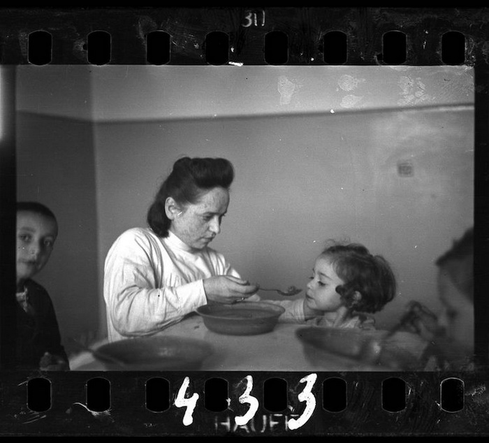 Женщина кормит ребенка в сиротском доме.
