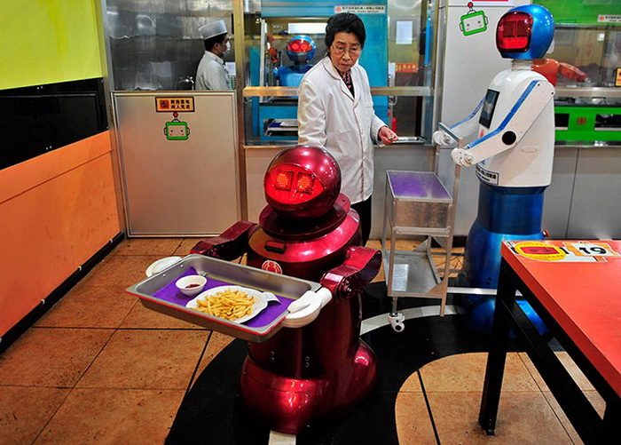 Несколько людей координируют работу роботов в ресторане