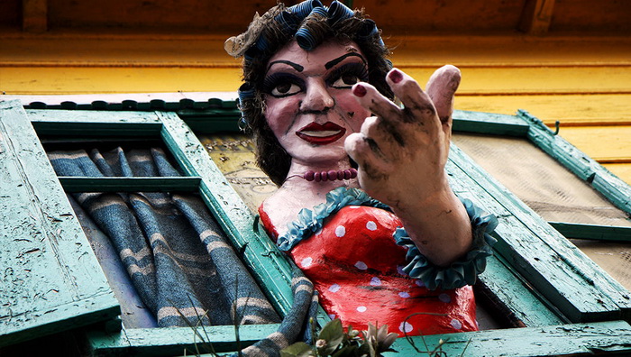 Куклы, изображающие танцовщиц-куртизанок, красуются из окон разноцветных аргентинских домов
