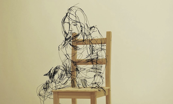 Девушка, сидящая на стуле.
