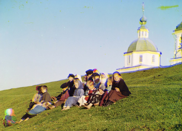 Русские дети сидят на холме недалеко от церкви у Белого озера в 1909 году