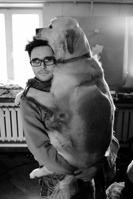 Черно-белый снимок хозяина с собакой на руках.