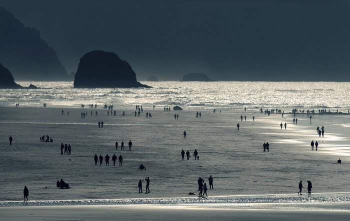 Силуэты людей на пляже на фотографии, сделанной Николасом Бувье (Nicolas Bouvier). 