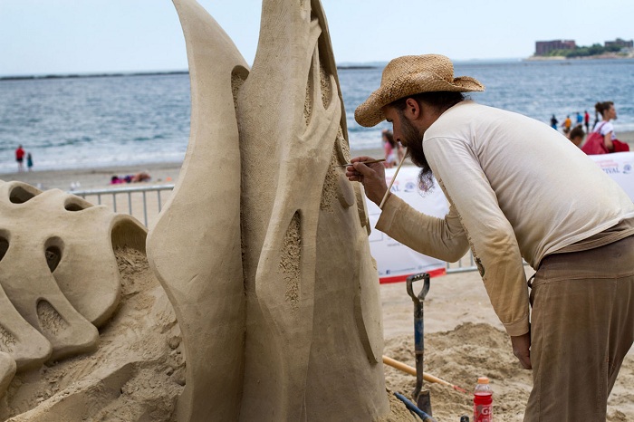 Скульптор создает свой шедевр из песка.