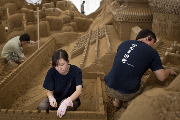 Работа над созданием скульптур из песка.