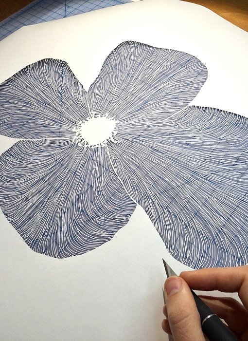 Процесс вырезания цветка из бумаги.
