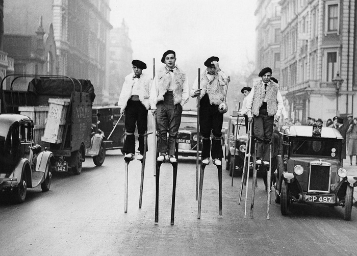 Танцоры на ходулях (из ланд), прогуливающиеся по улице Лондона по пути к Albert Hall, 1937 год.