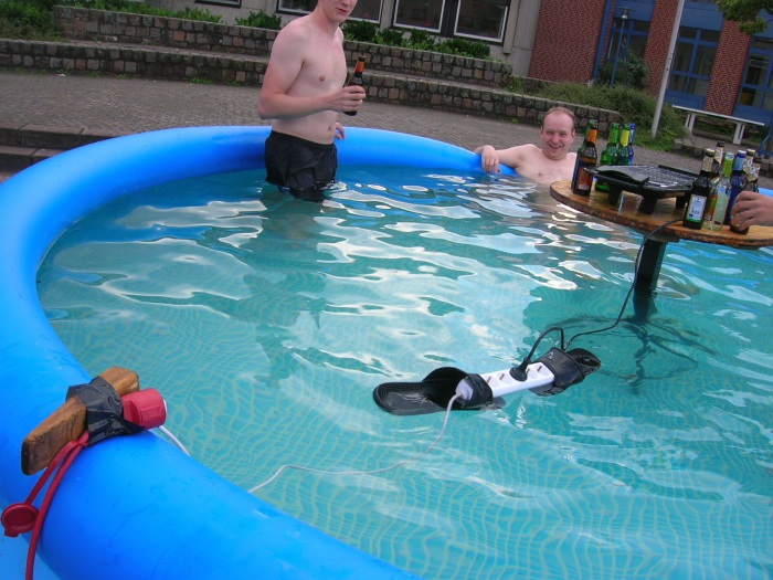 Удлинитель с вставленной в него вилкой, плавает прямо в бассейне.