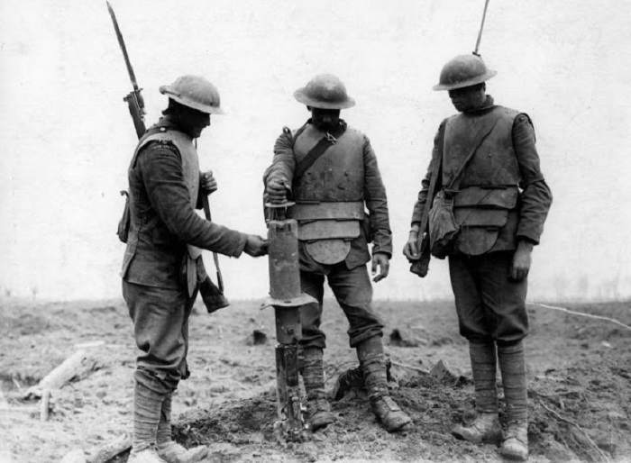 Три ирландский гвардейца, одетые в немецкие бронежилеты, осматривают трофейный немецкий пулемет на хребте Пилкем, 31 июля 1917 года. | Фото: vintag.es.