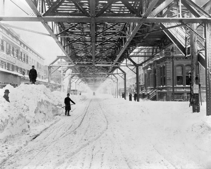 Работники расчищают снег под железной дорогой после метели.