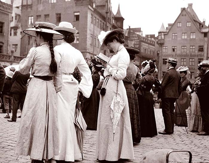 Дамы, по-видимому, туристки, стоят у Фрауэнкирхе в Нюрнберге, Германия.