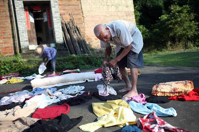 Кишоу помогает жене складывать одежду.