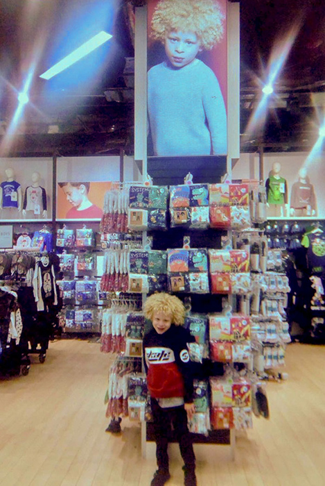 Элайджа в магазине рядом со своей фотографией.