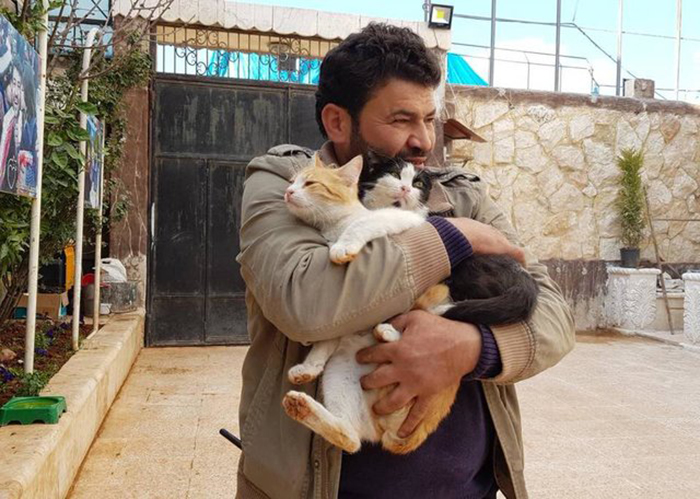 Мохаммед обнимает котов в своем приюте для животных.