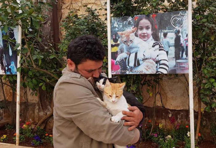 Мохаммед держит своего кота Эрнесто и кота из приюта Спаркса.