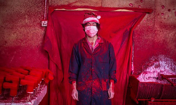 19-летний Веи работае на одной из фабрик Китая, покрывая игрушечных снеговиков красной краской.