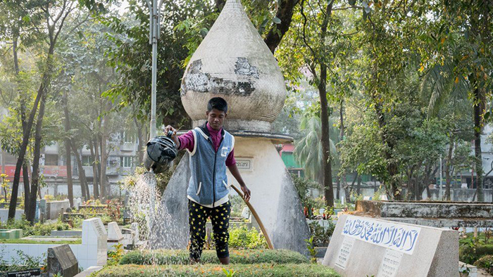 Мужчина поливает могилу на одном из кладбище в Дакке. Фото: Amirul Rajiv.