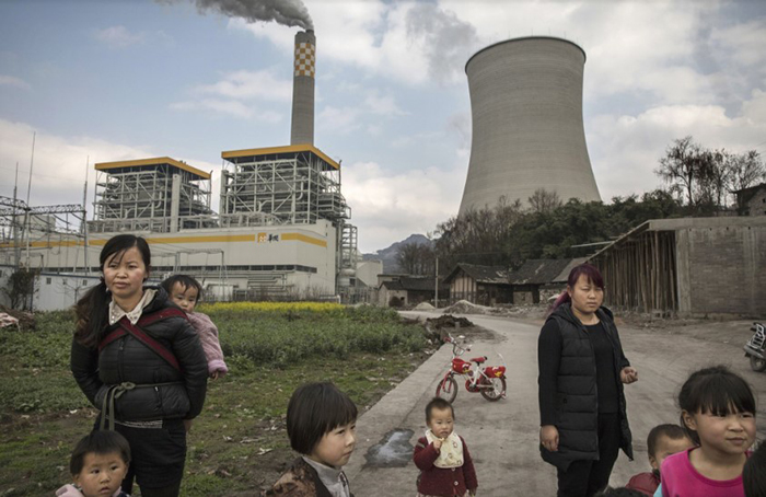 Жители деревни рядом с недавно построенным заводом, загрязняющим воздух. Китай.