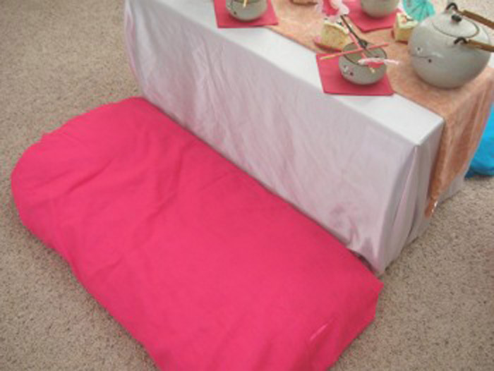 Стол мама сделала из обычной коробки, покрыла ее скатертью, а рядом положила обычные подушки.