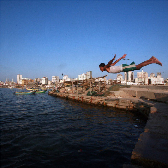 Мальчик прыгает в воду.  Фото: Emad Samir Nassar.