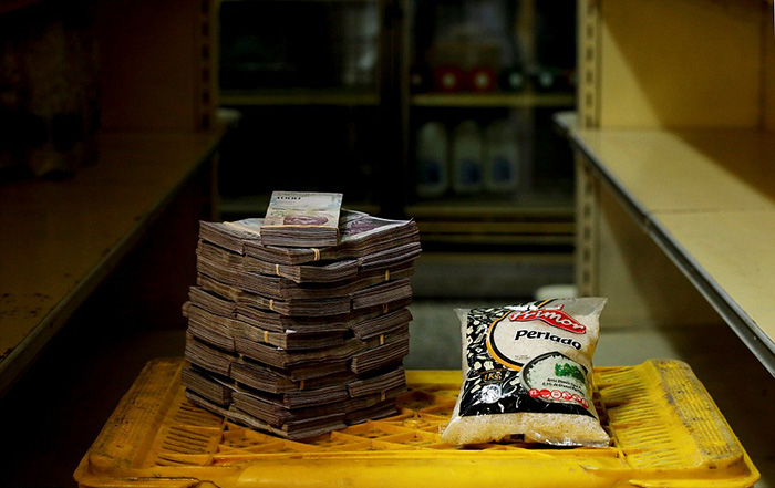 Килограммовая упаковка риса рядом с суммой денег, необходимой для его приобретения - 2 500 000 боливаров.