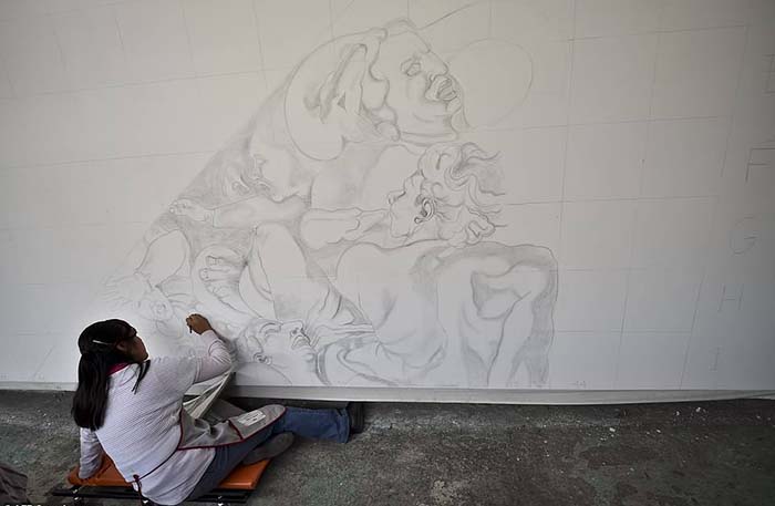 Волонтер Элизабет Рамирес работает над воспроизведением фрески Микеланджело.