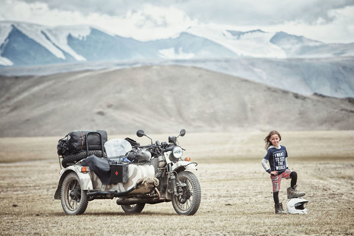 Владимир стоит рядом с мотоциклом Урал, на котором семья совершает все свои путешествия.  Instagram bizoo_n.