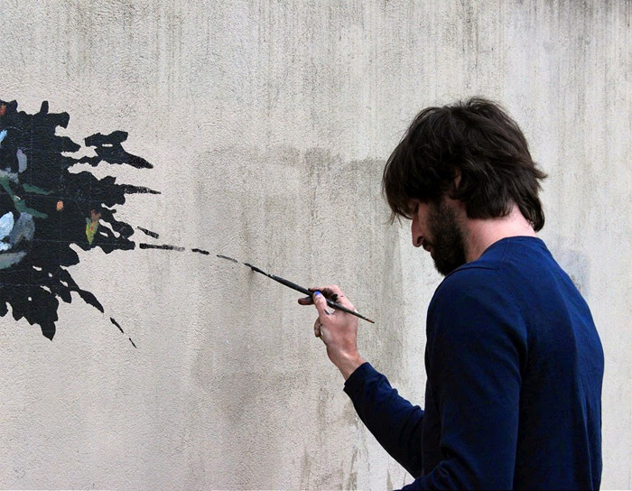 Испанский уличный художник Pejac в процессе создания работы «Вандал-изм».