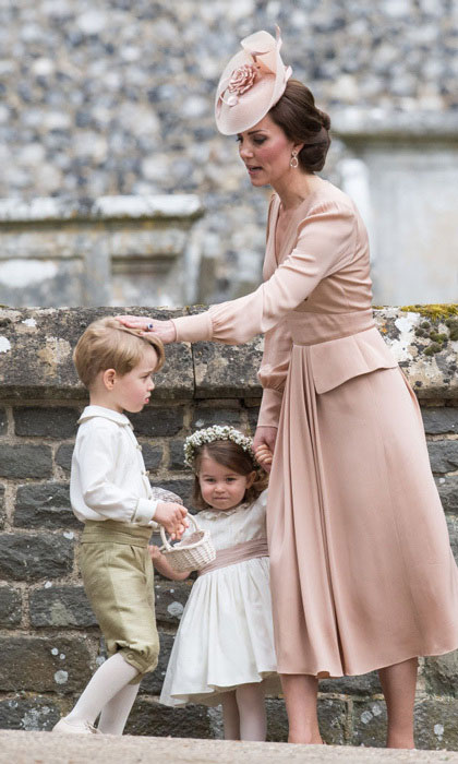 Кейт держит за руку двухлетнюю Шарлотту и поправляет прическу Джорджа. Перед началом свадьбы Пиппы, Кейт сказала, что единственное, о чем она беспокоится, это чтобы ее дети вели себя прилично.