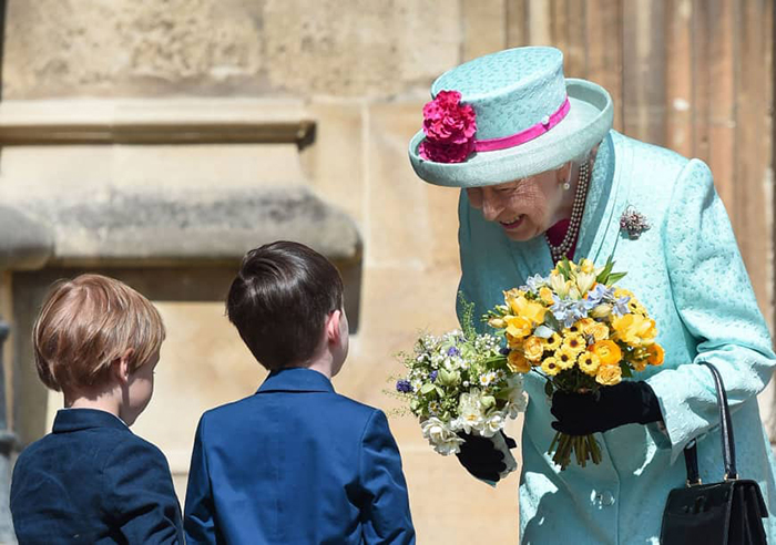 Королева получила в подарок букеты цветов от школьников во время посещения церкви на Пасху.