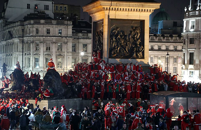 Тысячи людей в костюмах Санты на Трафальгарской площади в Лондоне.