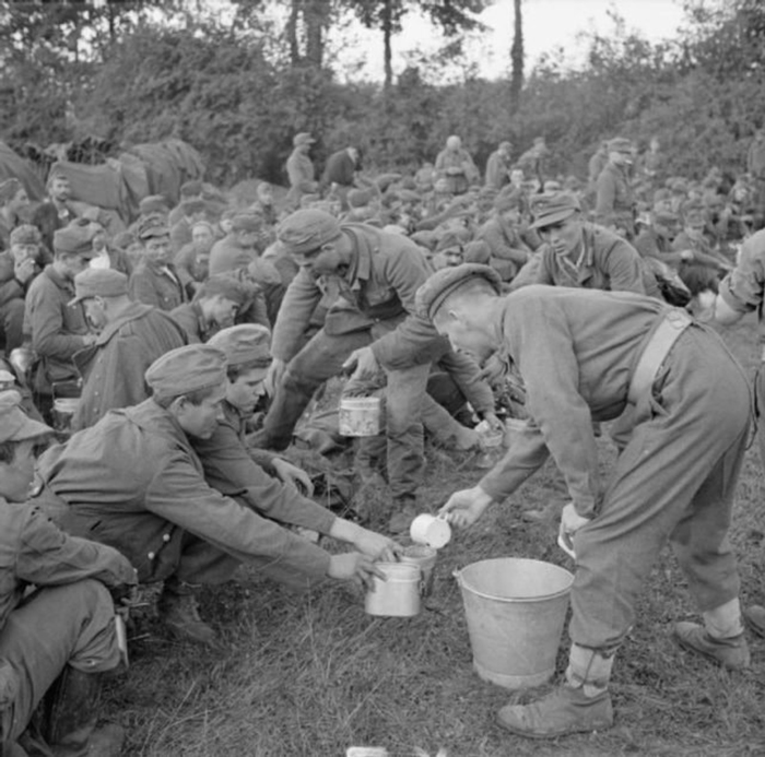 Британская армия в Нормандии - Солдат принес чай немецким пленным. 22 августа 1944г.