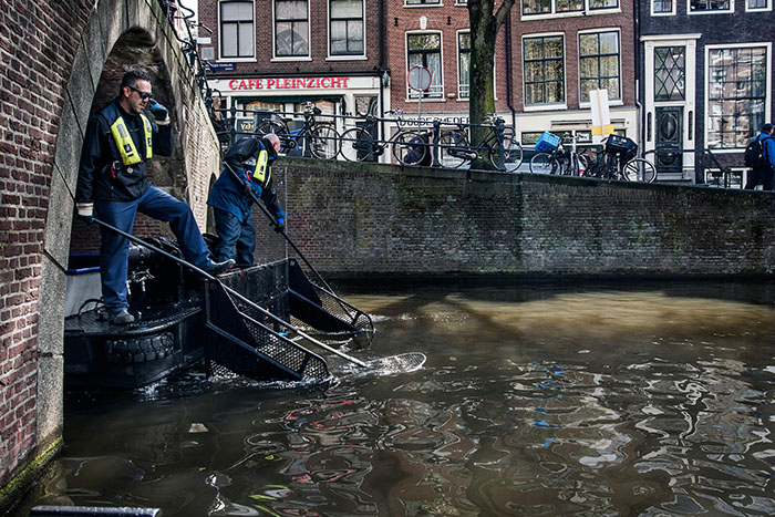 Городские службы очищают от мусора каналы Амстердама.