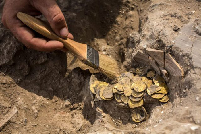 Израильский археолог Шахар Криспин чистит золотые монеты. Коллекция из 425 золотых монет, большинство из которых относится к периоду Аббасидов около 1100 лет назад.