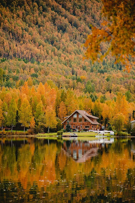 Осенний домик на зеркальном озере на Аляске.