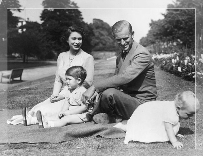 Принцесса Елизавета и принц Филипп, герцог Эдинбургский со своими двумя детьми, принцем Чарльзом и принцессой Анной, на территории Кларенс-Хауса, 1951 год.