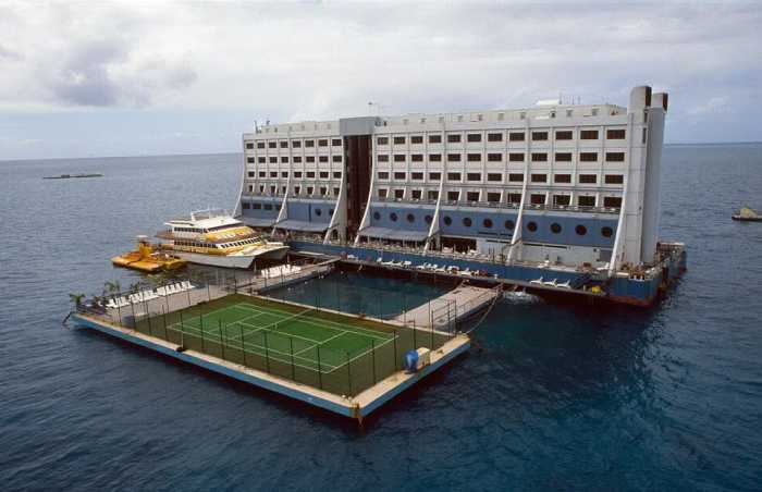 Семиэтажное здание плавучего отеля и теннисные корты.