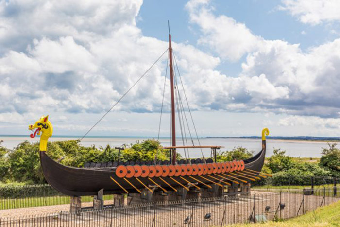 Восстановленное парусное судно или баркас викингов в заливе Пегуэлл в Кенте, Великобритания.